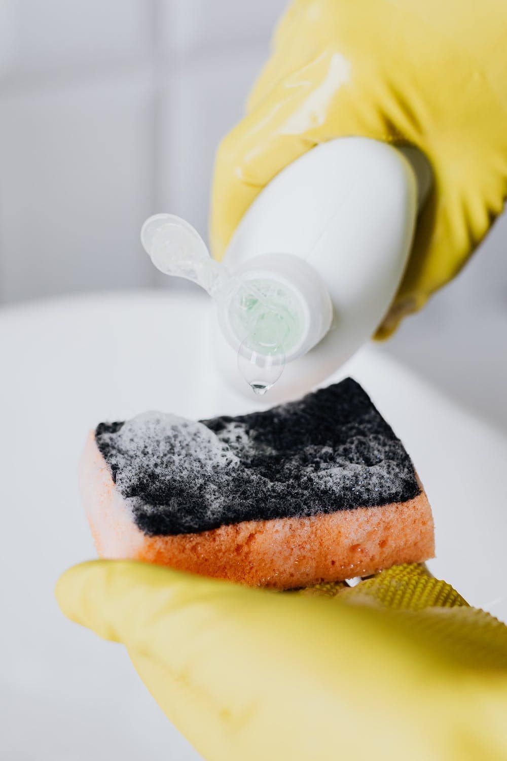 pouring dish soap on sponge