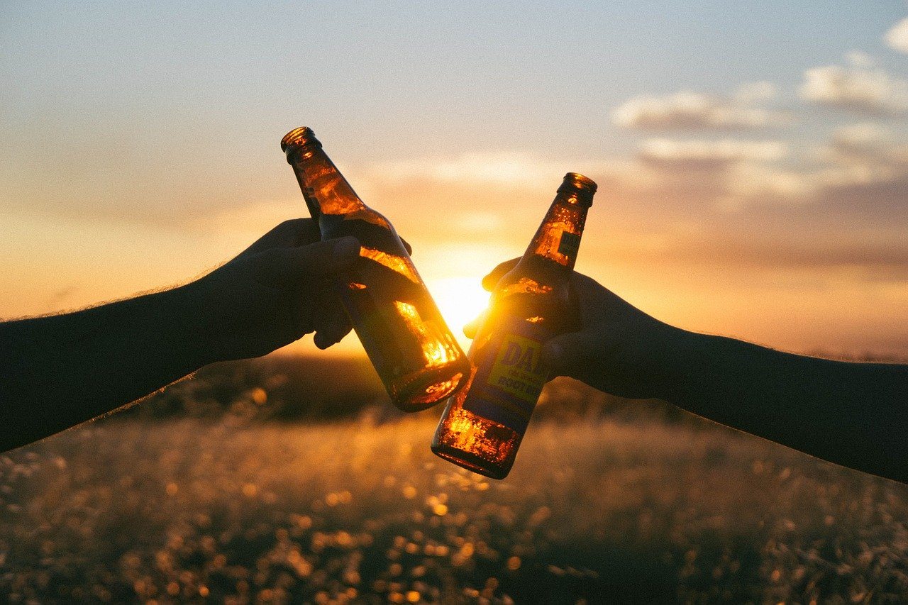 cheers with bottles of alcohol