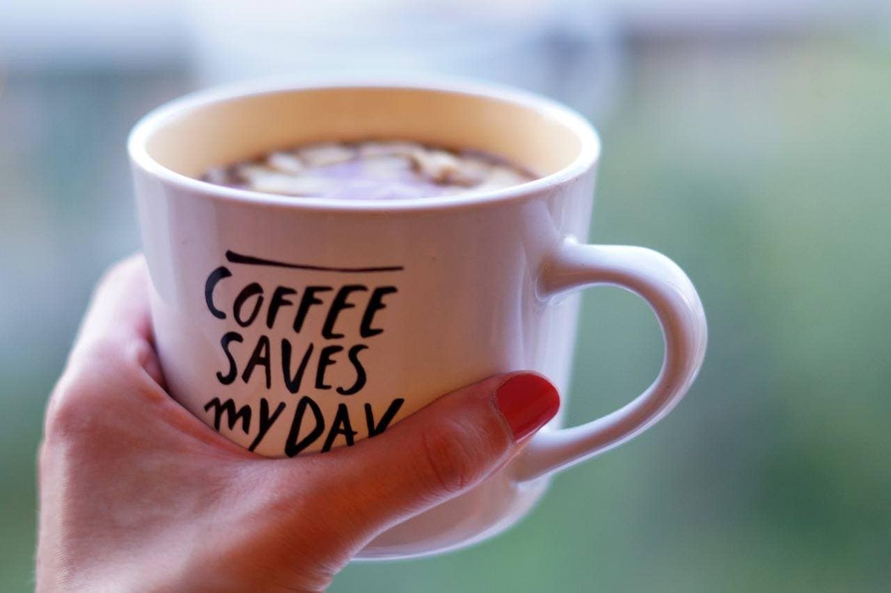 hand holding a cup of coffee