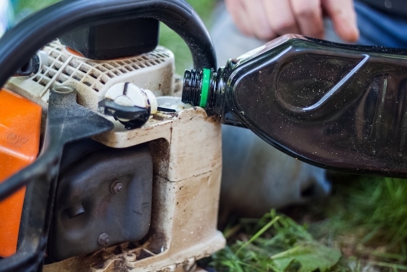 Adding oil to chainsaw