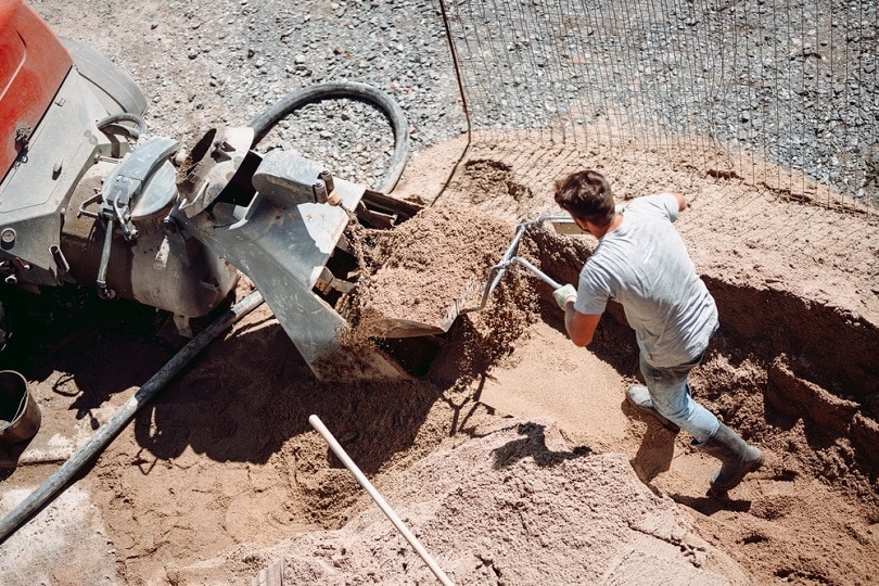 Construction worker using automatic pump for sand_bogdanhoda_shutterstock