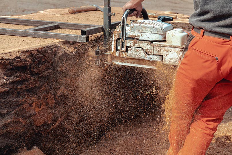 cropped man cutting a truck with chainsaw
