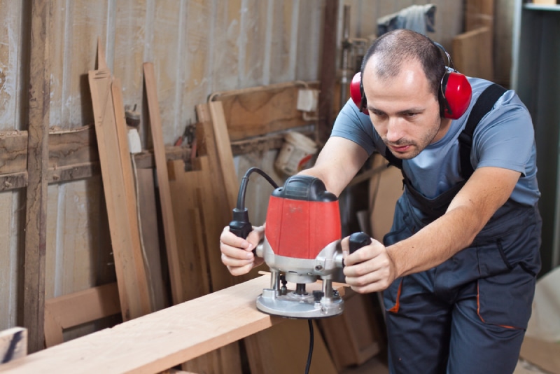 male worker using a wood router