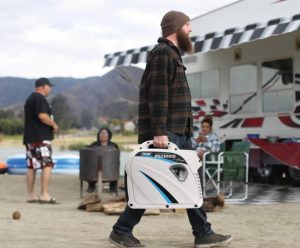 man carrying Pulsar G2319N Portable Gas-Powered Inverter Generator
