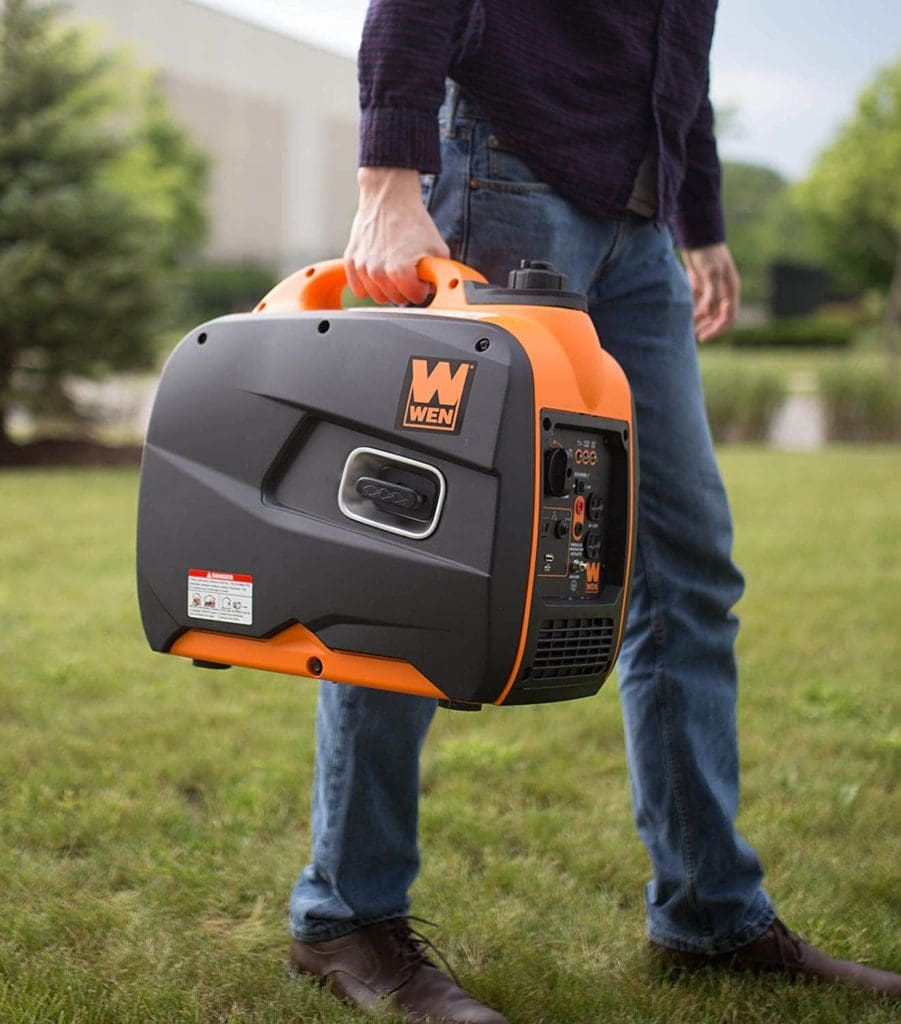man carrying Wen 56200i Portable Generator