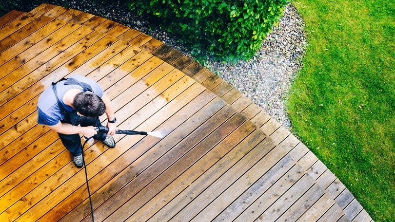 man cleaning terrace with a power washer_bubutu_shutterstock