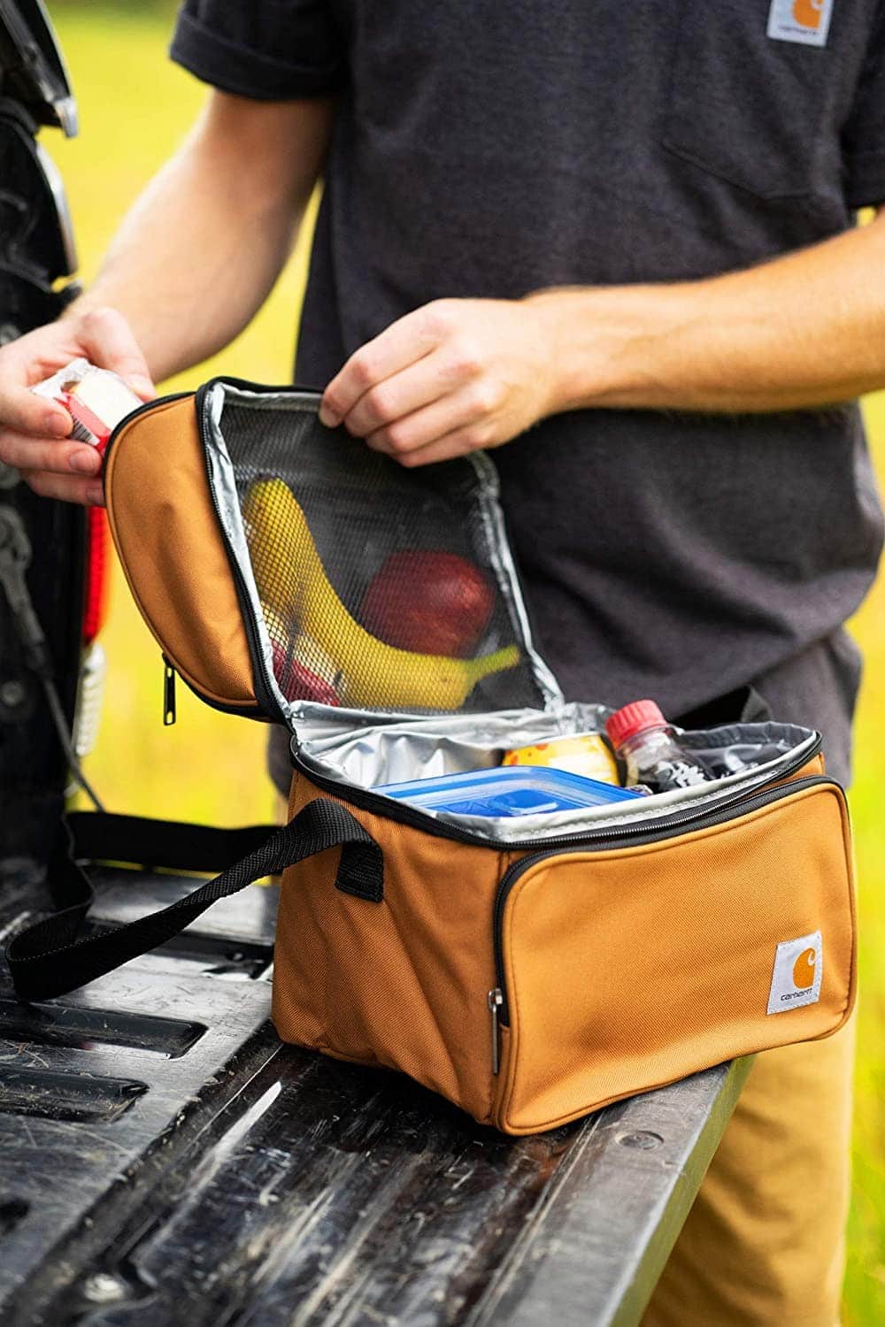 man holding Carhartt Deluxe Dual Compartment Insulated Lunch Cooler Bag