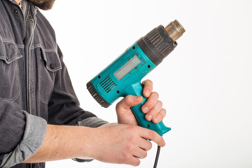 man holding heat gun upwards