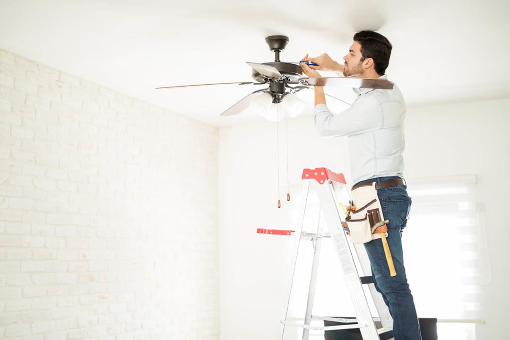 man installing a ceiling fan