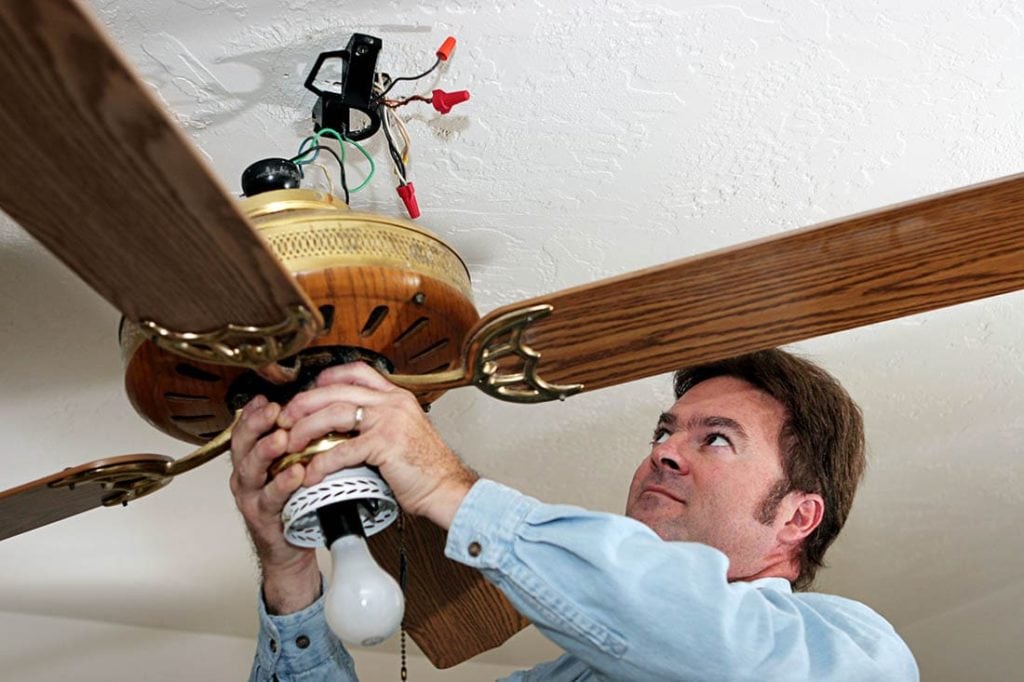 man installing ceiling fan
