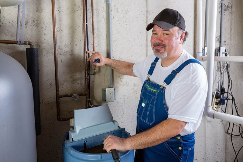 man installing water softener