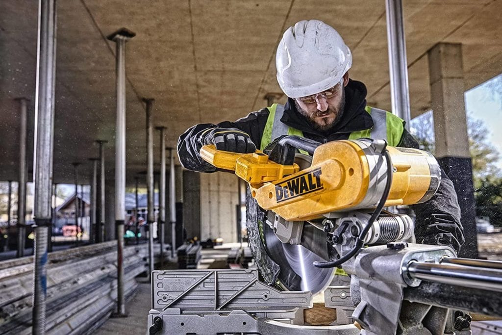 man using DEWALT DWS780 12-Inch Double Bevel Sliding Compound Miter Saw