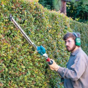 man using Makita XNU01Z Pole Hedge Trimmer