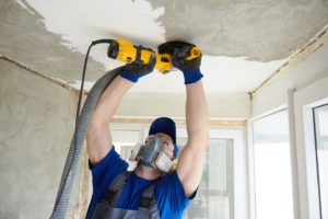 man using a dust collector while grinding