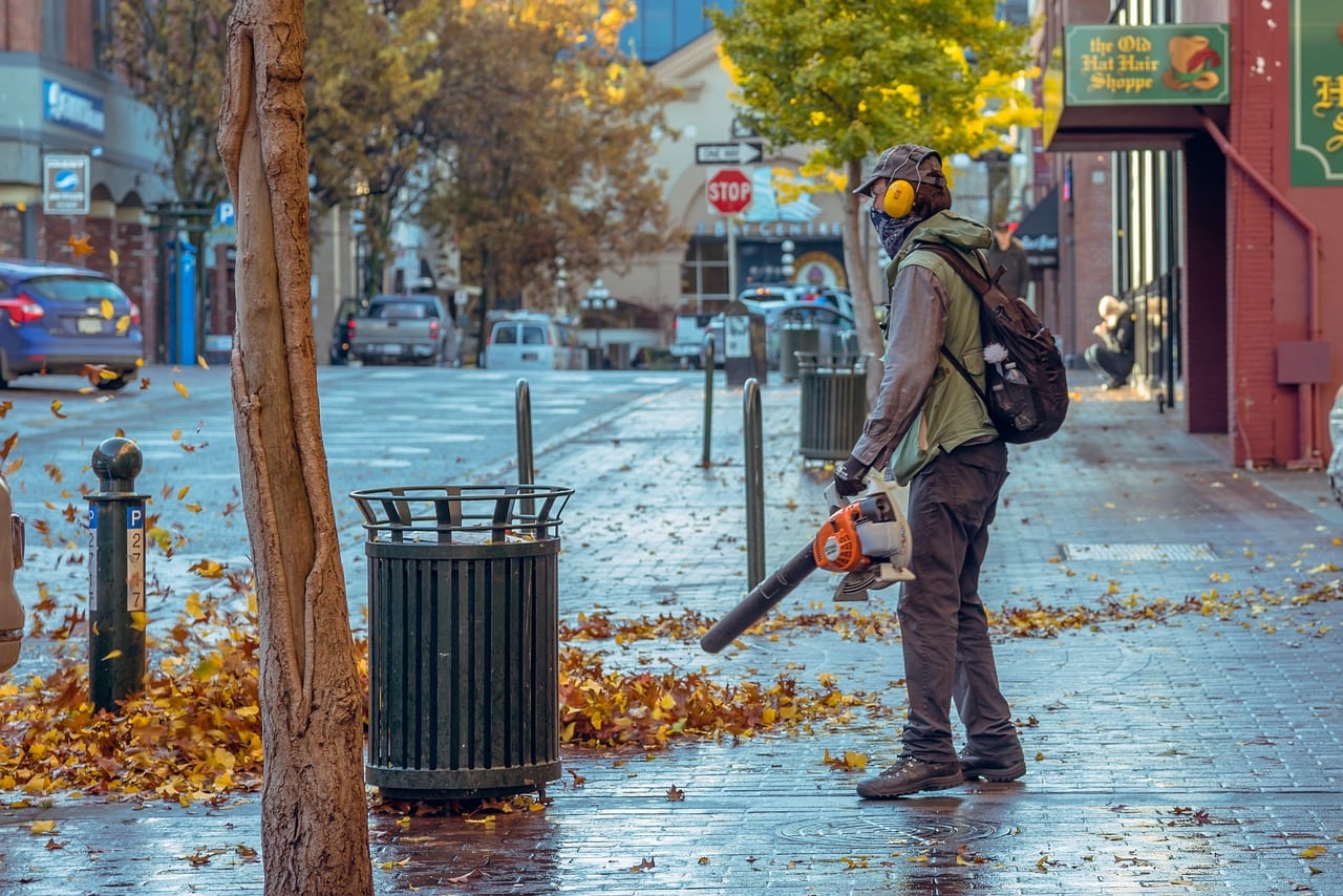 person clearing path with leaf blower