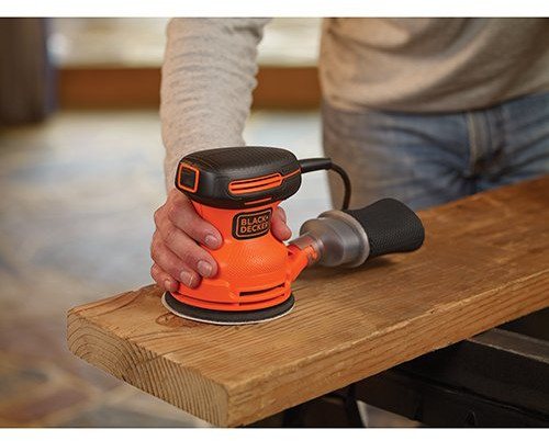 man using palm sander on wood