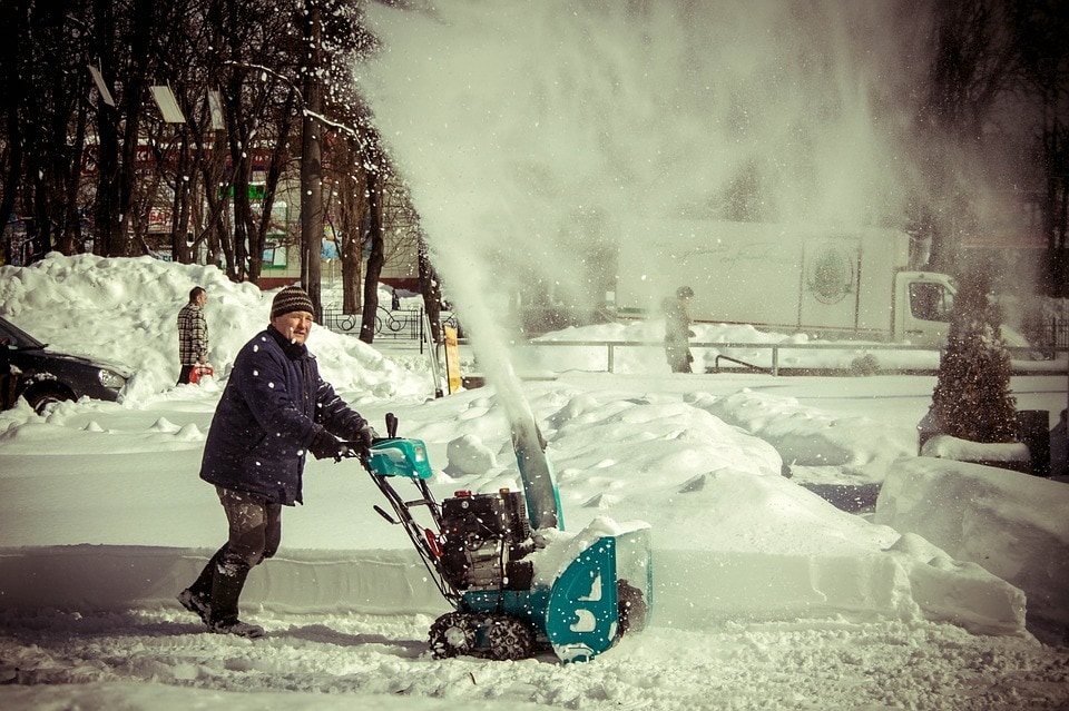 man using snow blower