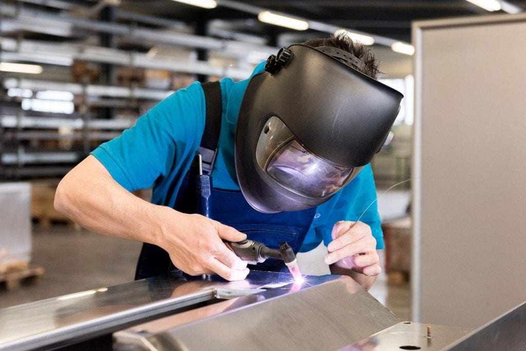 man wearing welding helmet while working