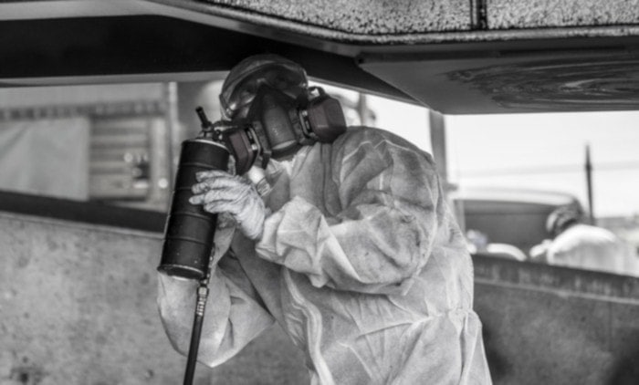 man prepares to spray undercoat paint