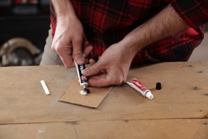 person using J-B Weld 8281 Professional Size Steel Reinforced Epoxy