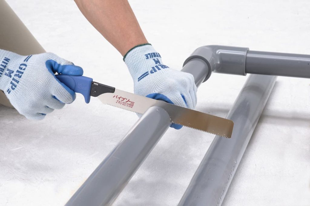 person using pipe saw to cut pvc pipe