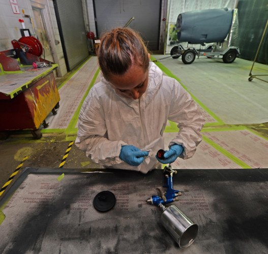 woman cleaning spray paint gun