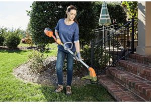 woman holding Husqvarna 115iL Battery Straight Shaft String Trimmer
