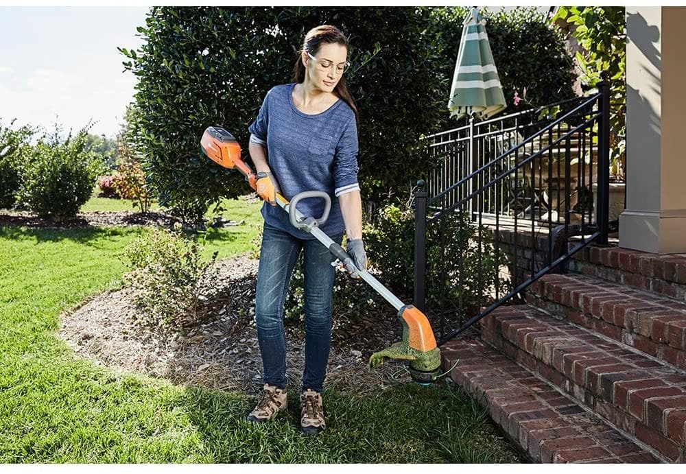 woman holding Husqvarna 115iL Battery Straight Shaft String Trimmer