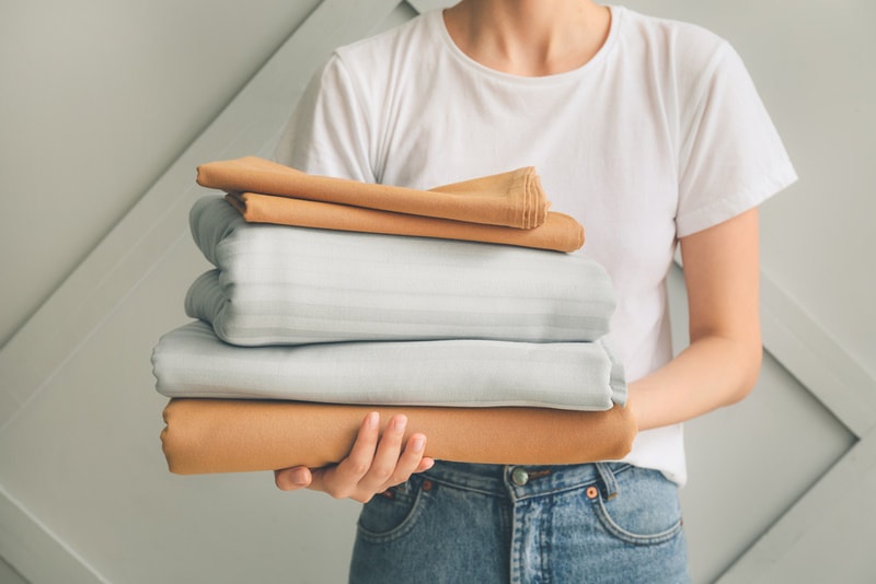 woman holding clean bedsheets