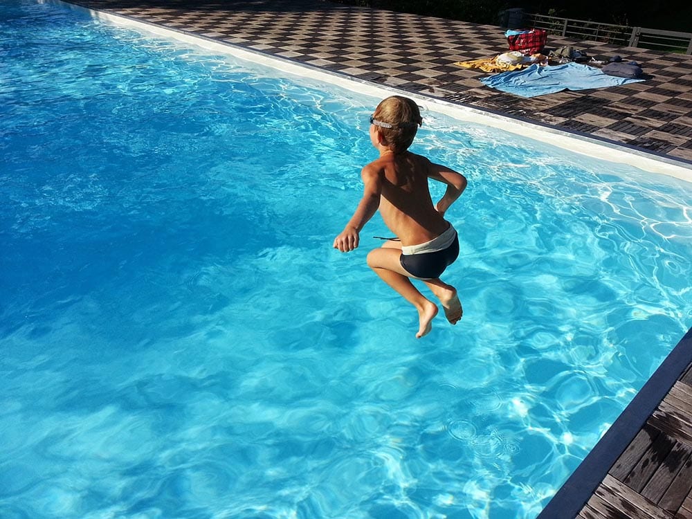 boy jumping to the fiberglass pool