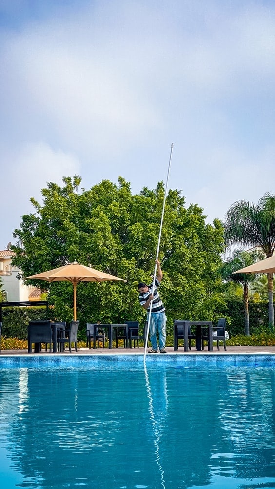 man cleaning pool