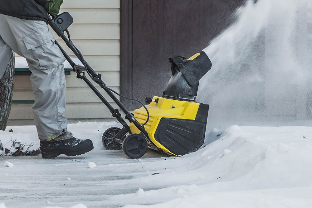 man using an electric snow blower