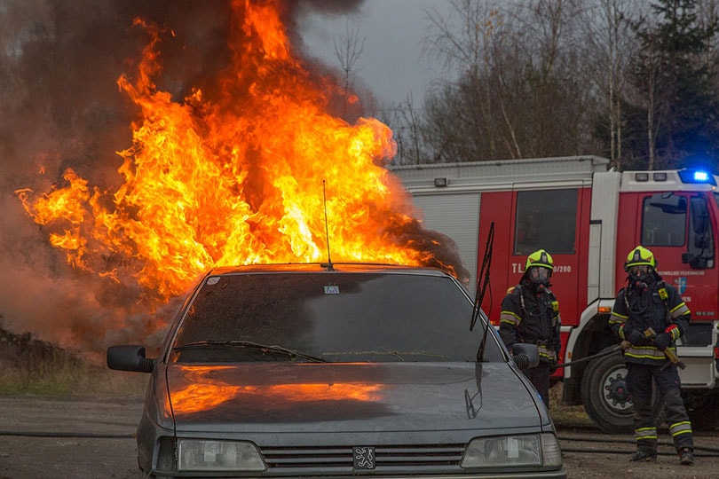 fire fighters watching car caught in fire