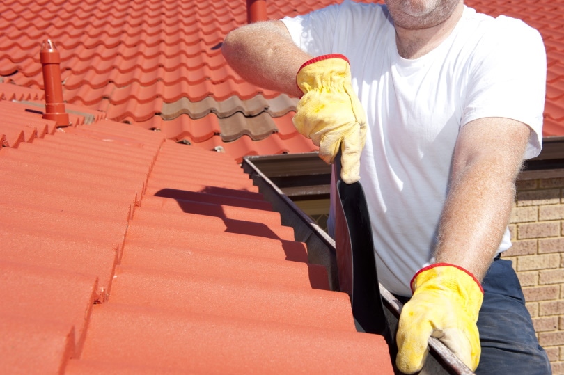 man cleaning gutter