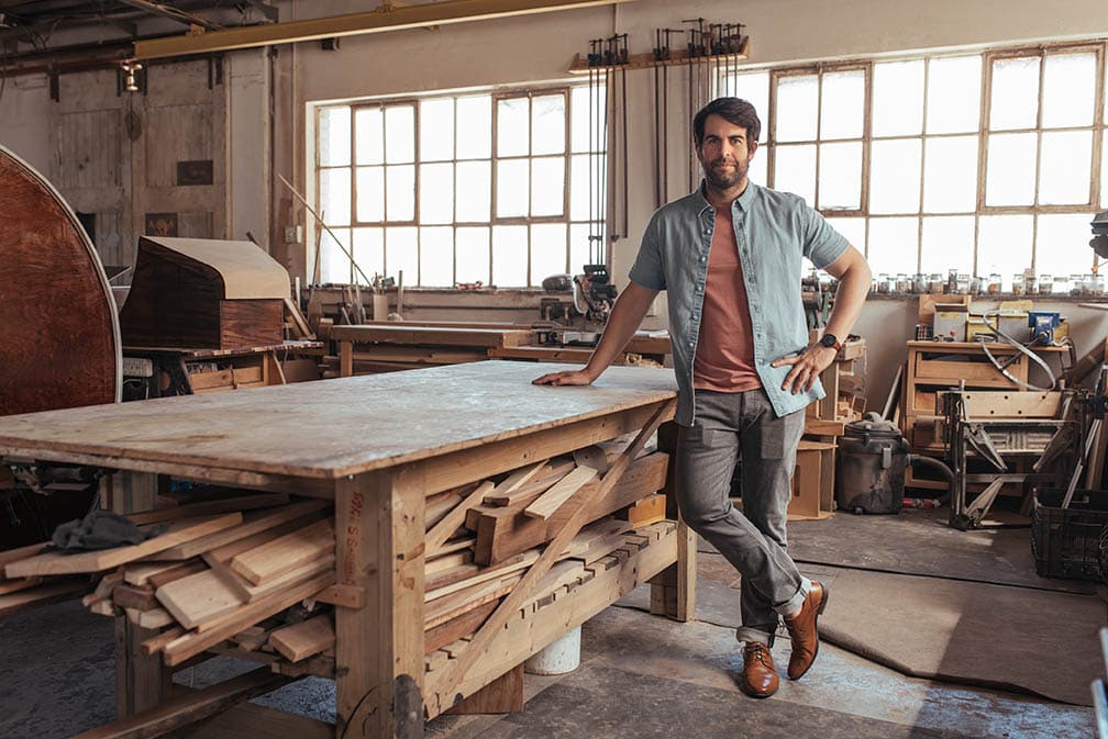 man standing beside a workbench