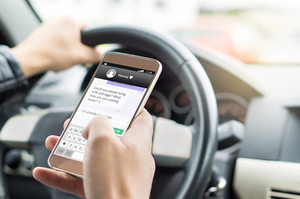 man texting while driving