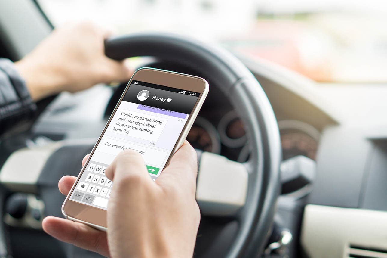 man texting while driving