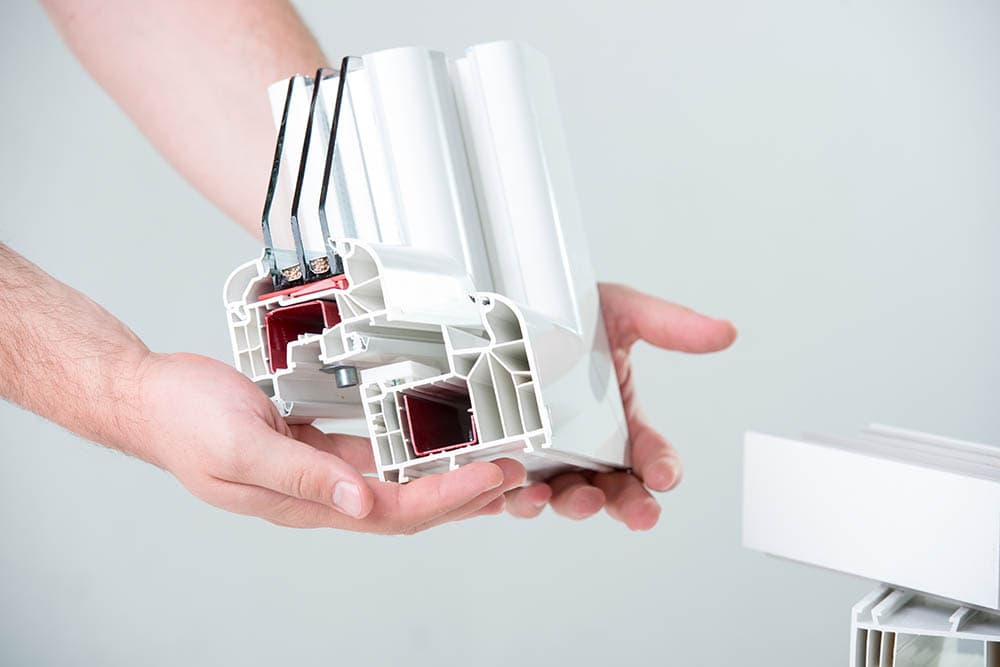 hand holding a sample of triple pane window