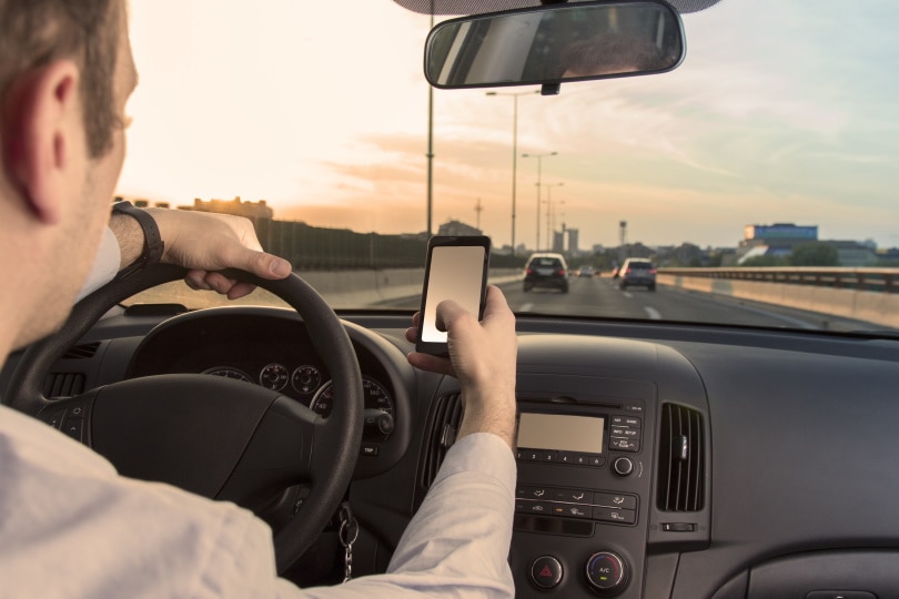 man using cell phone while driving