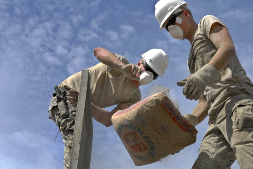 person dropping sack of cement