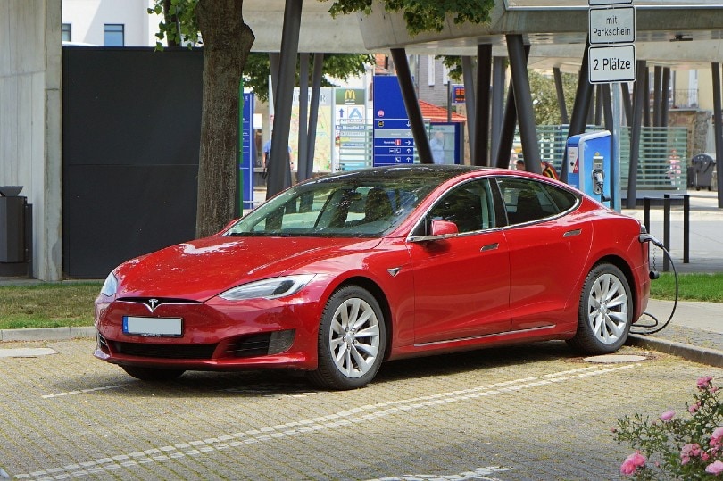 red tesla car being charged