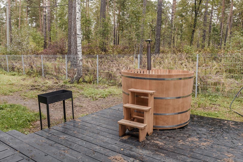 a cedar hot tub on a wooden veranda