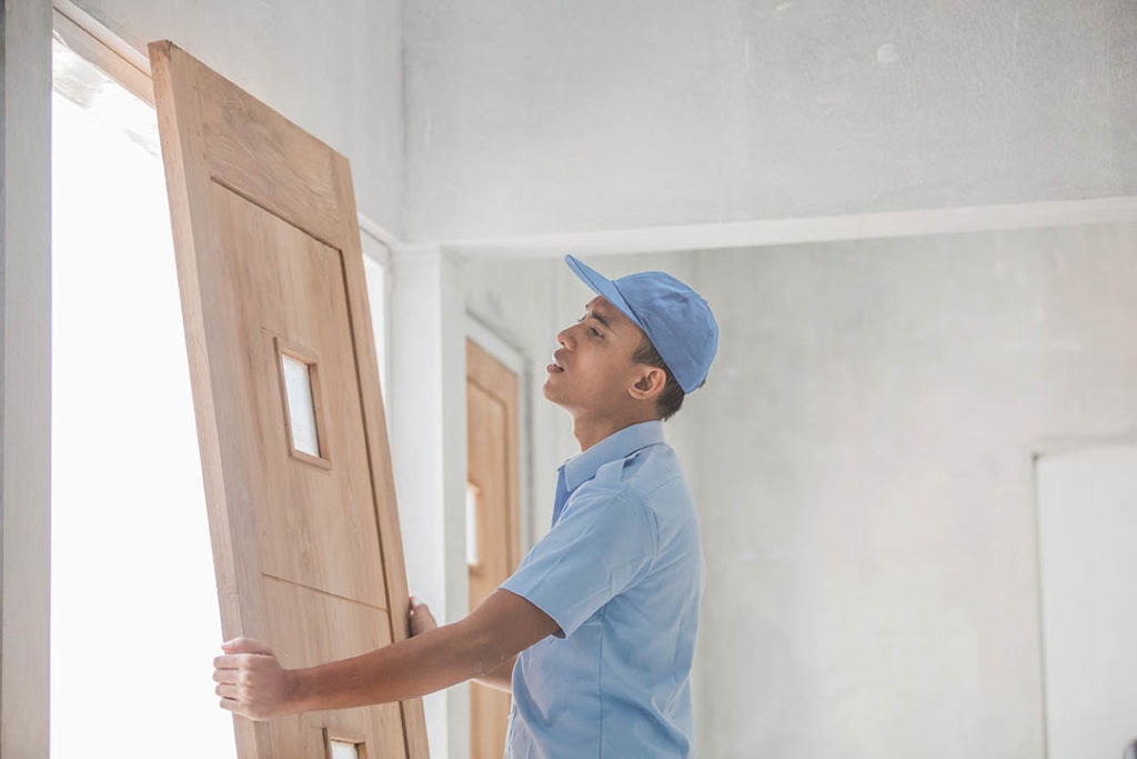 asian man installing exterior door