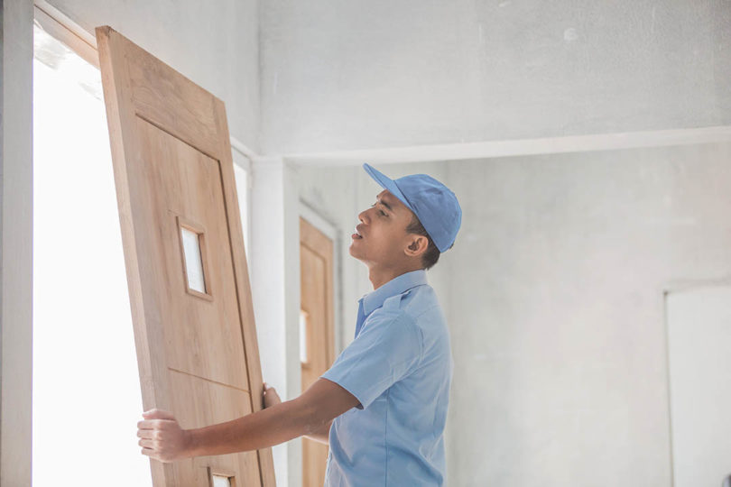 asian man installing exterior door