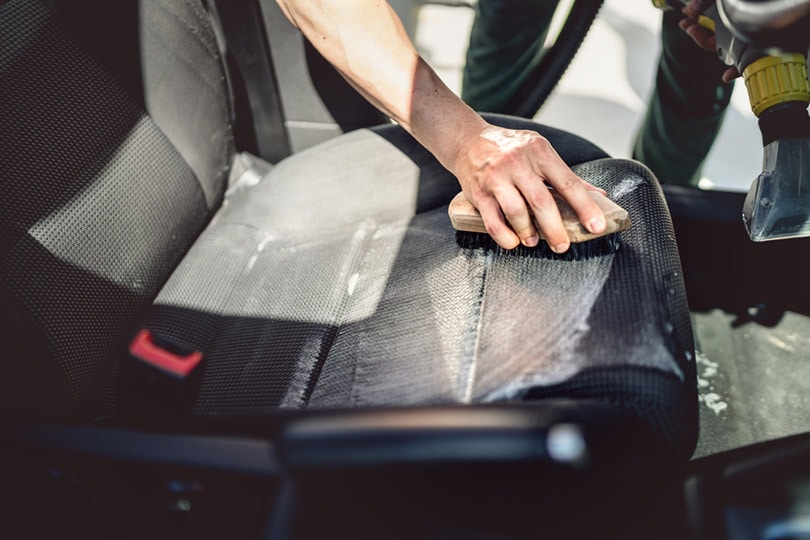 cropped man scrubbing the car seat