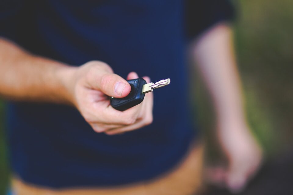 car keys in hand with blue shirt