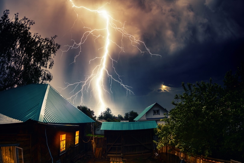 lightning strikes near house roofs