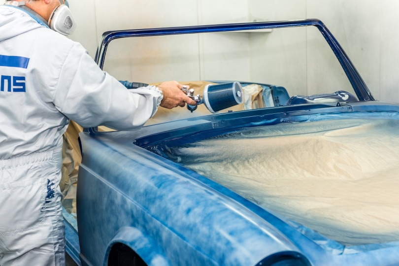 man painting car with blue color