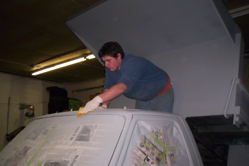 man sanding car paint
