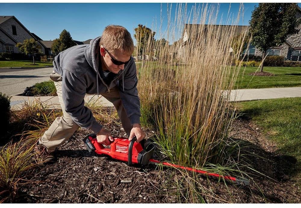 man using Milwaukee M18 Fuel 18-Volt Lithium-Ion Brushless Cordless Hedge Trimmer